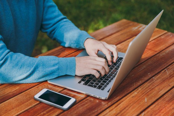 Photo of man writing on laptop illustrates blog: "4 Tips to Pawn or Sell Your Laptop"