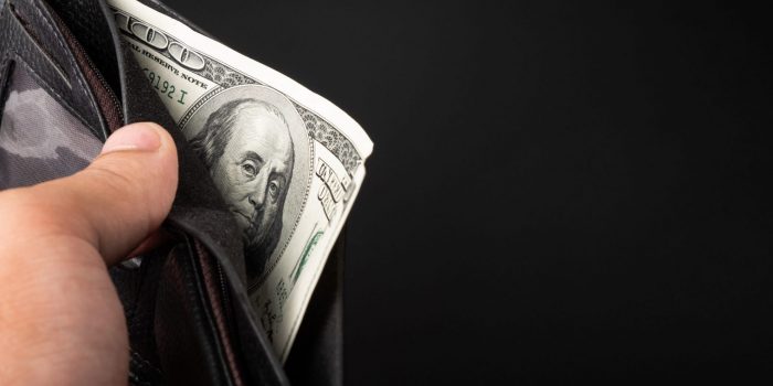 Closeup of hand holding wallet with 100 dollar bill illustrates blog "How Can I Make Cash in One Day?"