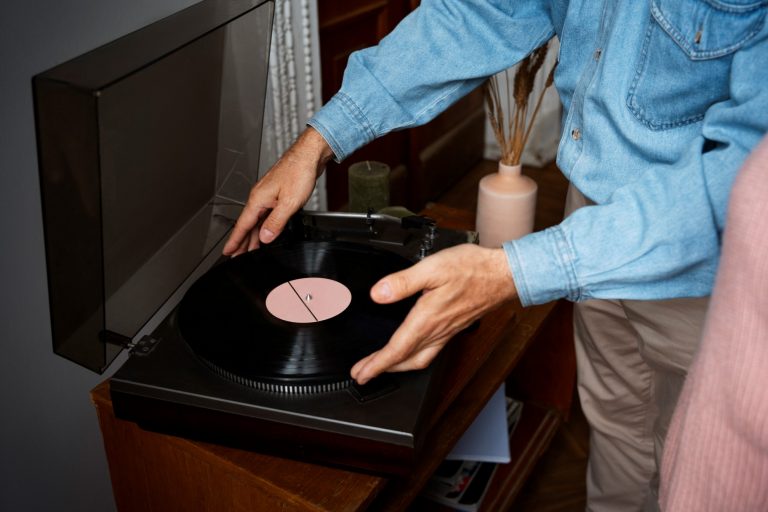 Man placing vinyl record on turntable illustrates blog "Is a Pawn Shop a Good Place To Buy and Sell Vintage Records?"