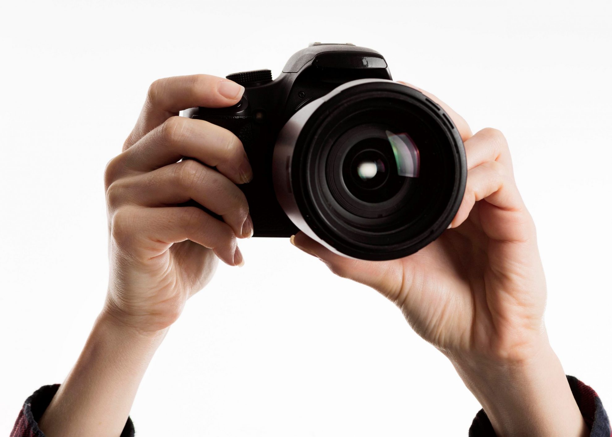 Closeup of hands holding camera illustrates blog "How To Pawn or Sell a Camera or Camera Lens?"