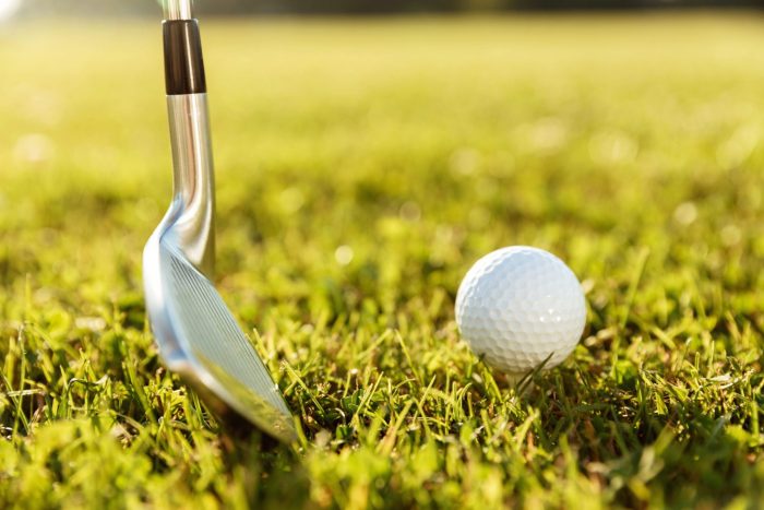 Golf club about to hit ball on the grass illustrates blog: "Do Pawn Shops Buy and Sell Golf Clubs?"