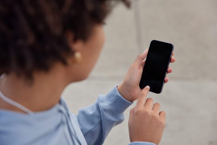 Photo of woman using smartphone illustrates blog "Do Pawn Shops Take iPhones?"