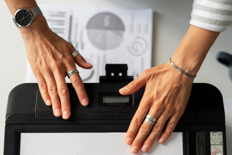 Closeup of hands on printer illustrates blog "Do Pawn Shops Take Printers?"
