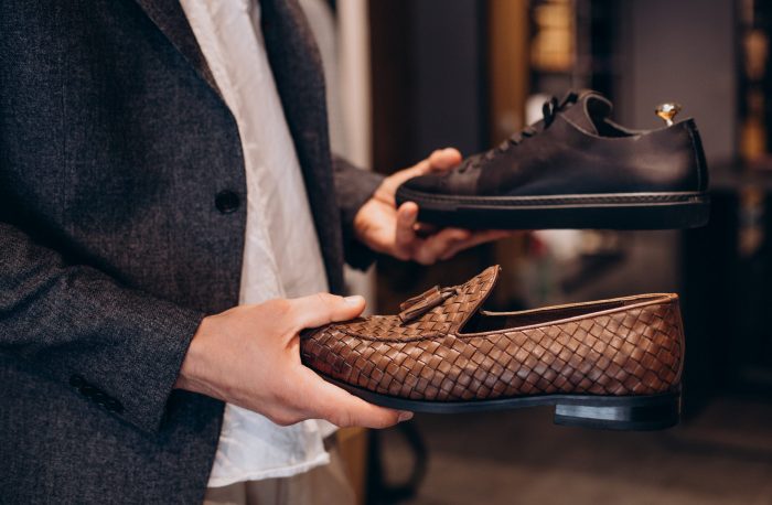 designer-shoes-seniv-petro Man holding luxury shoes in each hand illustrates blog "Can You Pawn Shoes? "