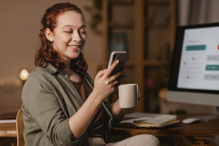Girl holdng cell phone in one hand and coffee cup in the other illustrates blog "Can I Sell my Cell Phone to a Pawn Shop? "