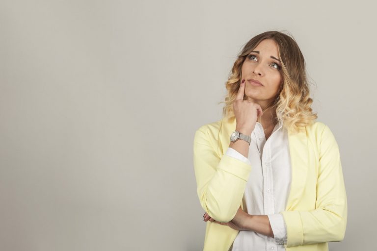 Thoughtful woman with right index on her chin illustrates blog "Is a Pawn Shop Loan a Good Idea?"