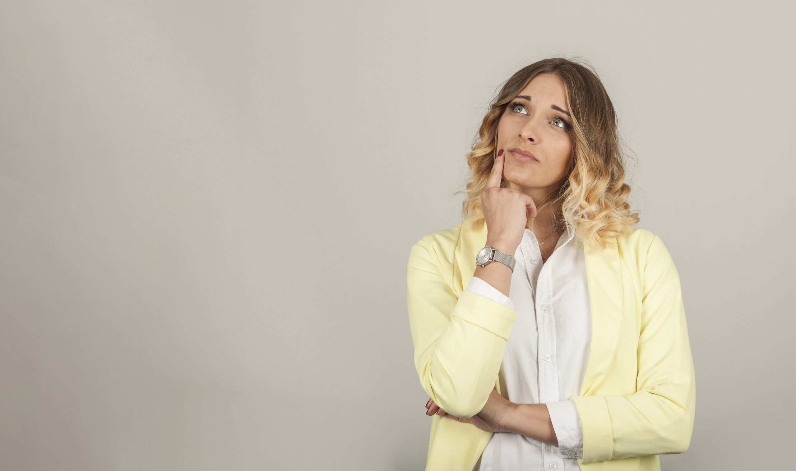 Thoughtful woman with right index on her chin illustrates blog "Is a Pawn Shop Loan a Good Idea?"