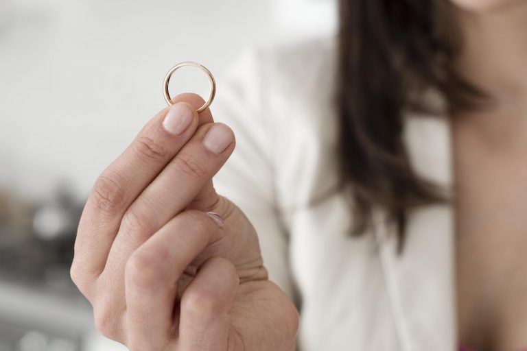 Closeup of woman holding ring illustrates blog "Can You Pawn Engraved Jewelry?"