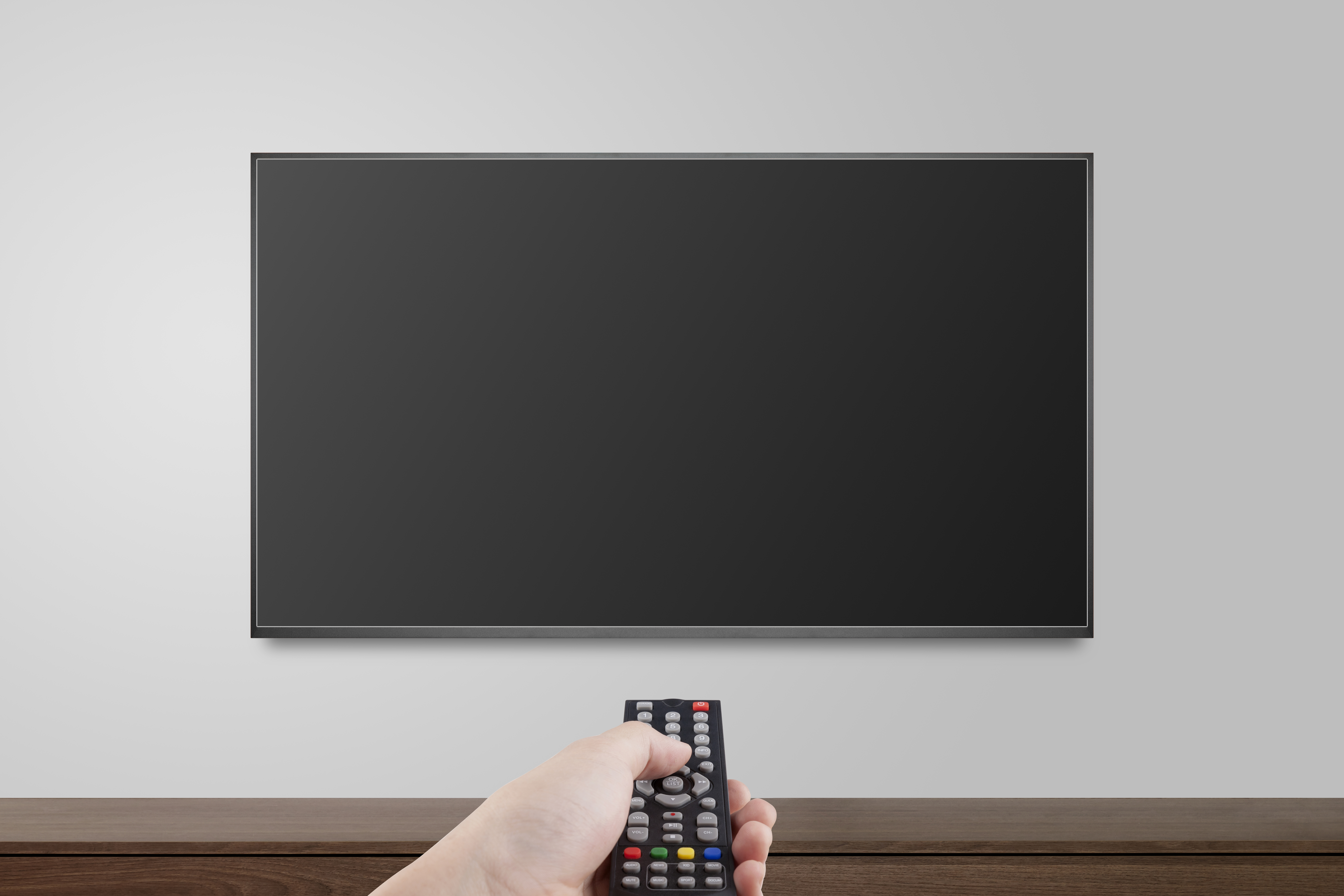 Television on white wall with hand using remote control, TV 4K f