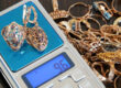Customer checking gold prices on smartphone before pawning gold jewelry