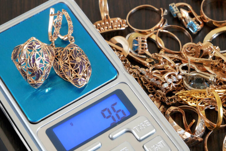 Customer checking gold prices on smartphone before pawning gold jewelry