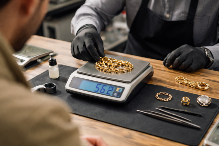 pawn shop evaluating pawn gold jewelry using scale and testing tools