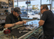Pawn shop pricing evaluation for jewelry, electronics, and tools at a service counter